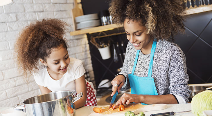 Beautiful African American woman and her daughter cooking in the Beautiful African American woman and her daughter cooking in the