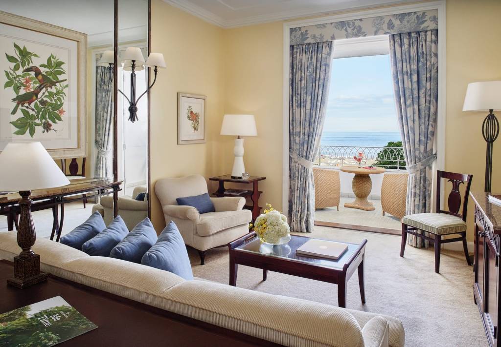 decoração-do-hotel-copacabana-palace Sala de estar da suíte de um quarto com mesa e poltronas na sacada, do Belmond Copacabana Palace (RJ)