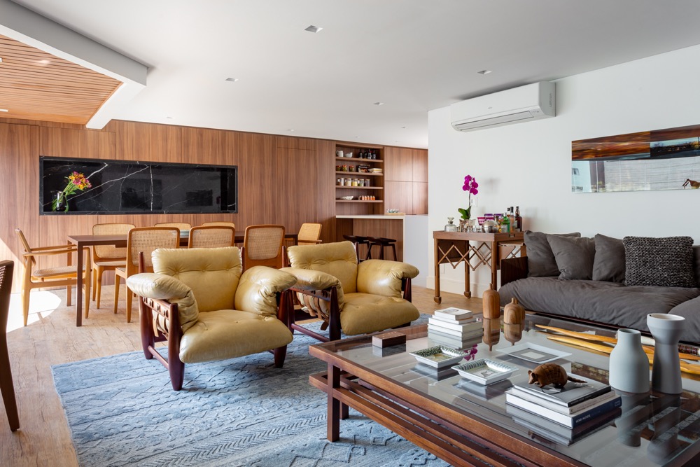 apartamento-Next-Arquitetura1 sala integrada com poltrona de couro e painel de madeira