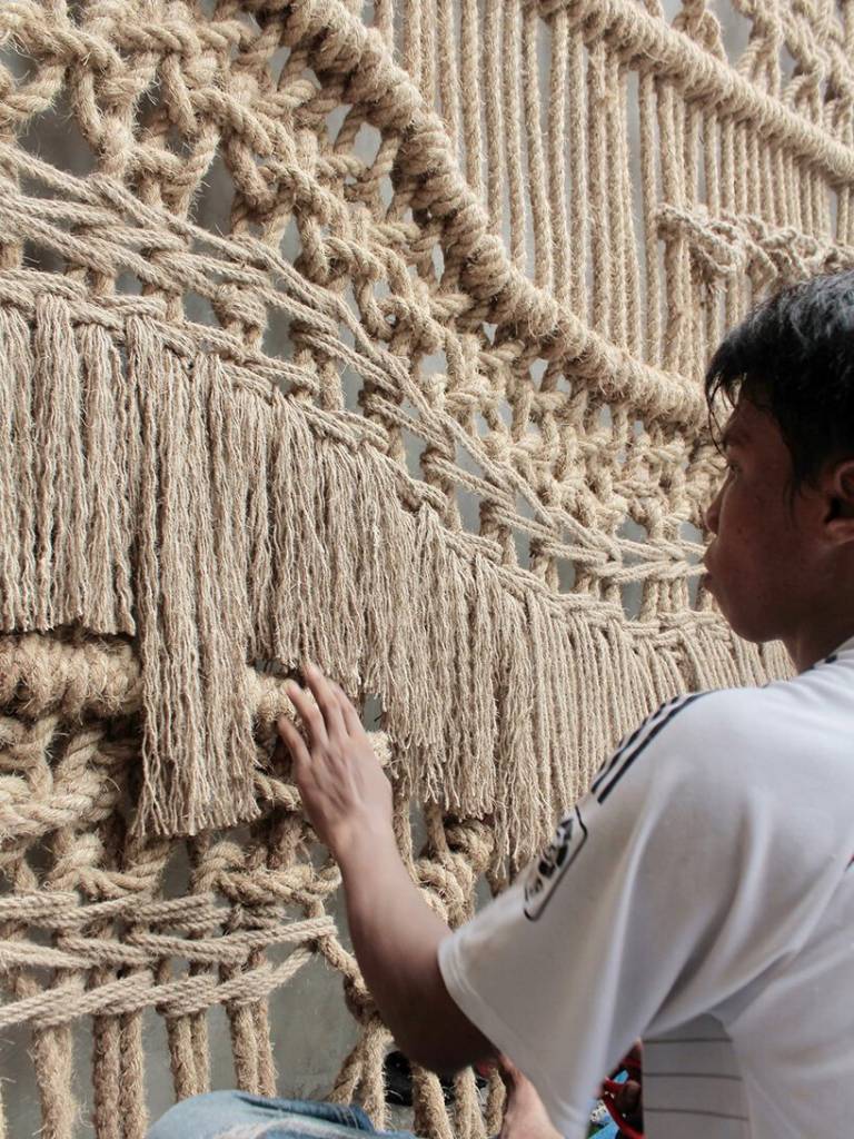 artista-tece-obra-gigante-feita-com-macrame-bali-casa.com-3 Homem mexendo no macramê da obra