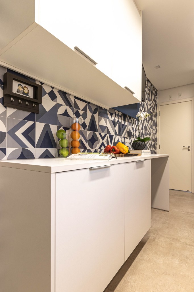 19 erros que você não pode cometer ao planejar a cozinha. Projeto de Gigi Gorenstein e executada pela MCC Arquitetura Na foto, cozinha com marcenaria branca, parede geométrica de azulejos.