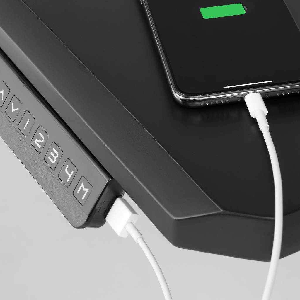 ikea-lanca-colecao-de-moveis-para-e-sports-casa.com-4 Lateral da mesa com a entrada USB com um fio branco conectado à ela e a um celular que está carregando
