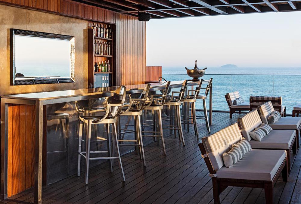 rooftop-a-tendencia-na-arquitetura-contemporanea-fasano-casa.com-3 Rooftop do Fasado, com deck, bar e cadeiras de madeira. Ao fundo, vista para o mar