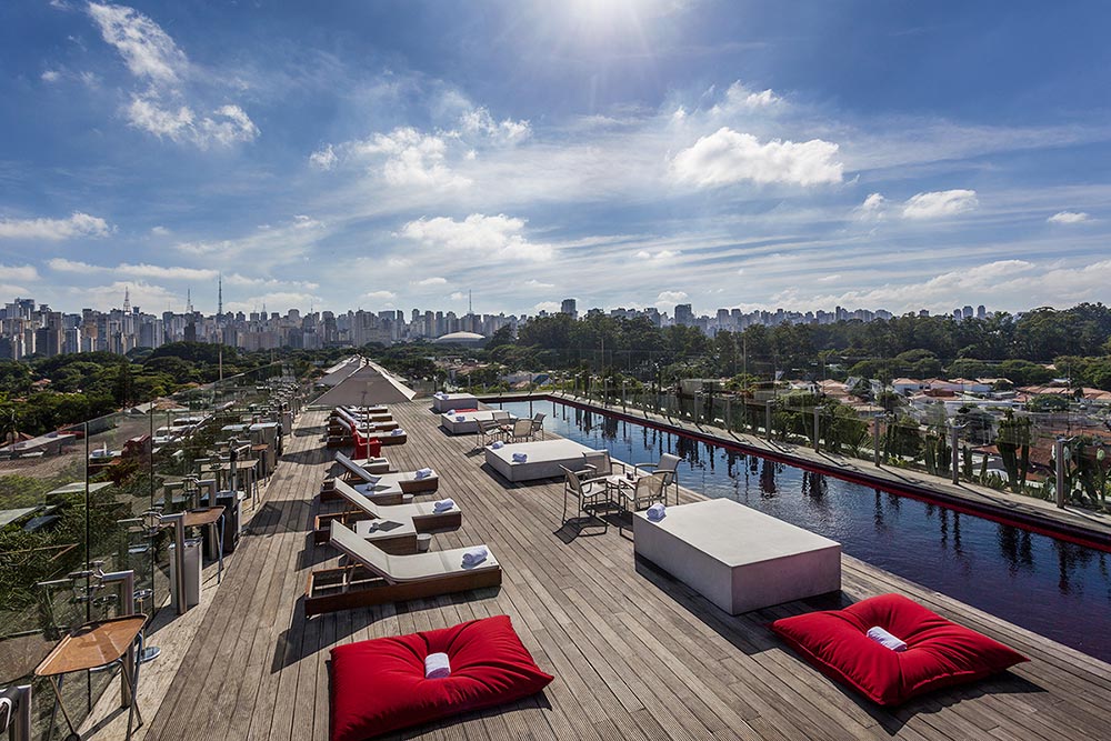 rooftop-a-tendencia-na-arquitetura-contemporanea-skye-bar-casa.com-2 Skye Bar, com deck de madeira, esteiras de praia, e uma piscina estreita e longa.