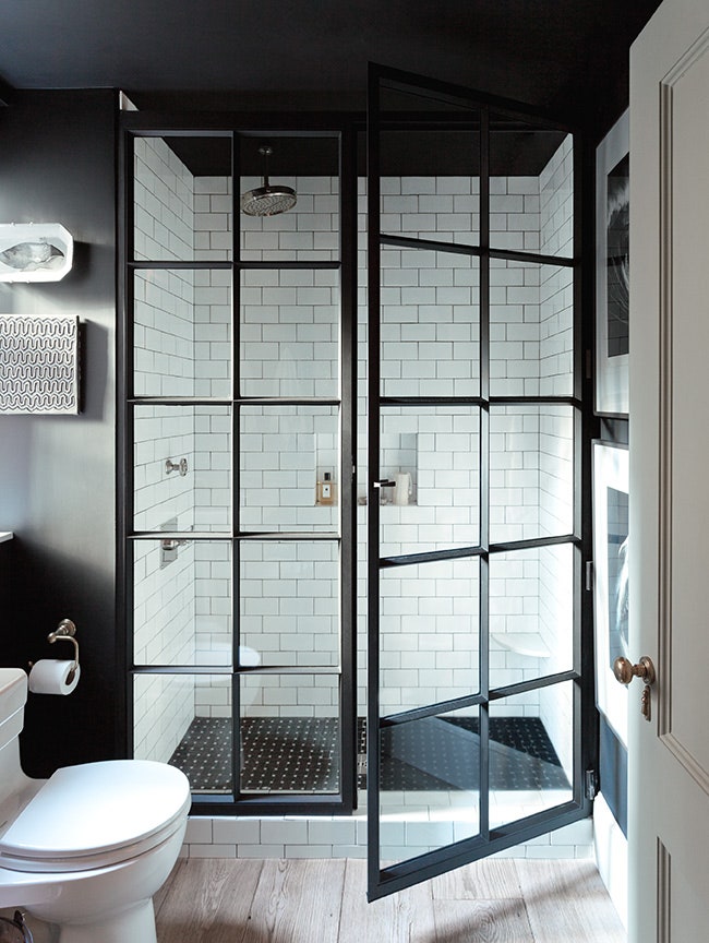 Banheiro preto e branco com box de vidro e estrutura quadrilculada preta