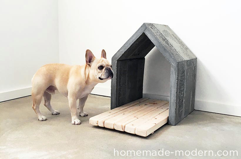 Casinha de cachorro feita de concreto com um deck de madeira para o cão deitar