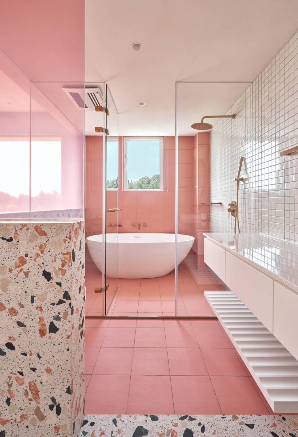 8-30-banheiros-lindo-demais-assinados-por-arquitetos Banheiro com banheira solta e revestimentos rosa com detalhes em granilite