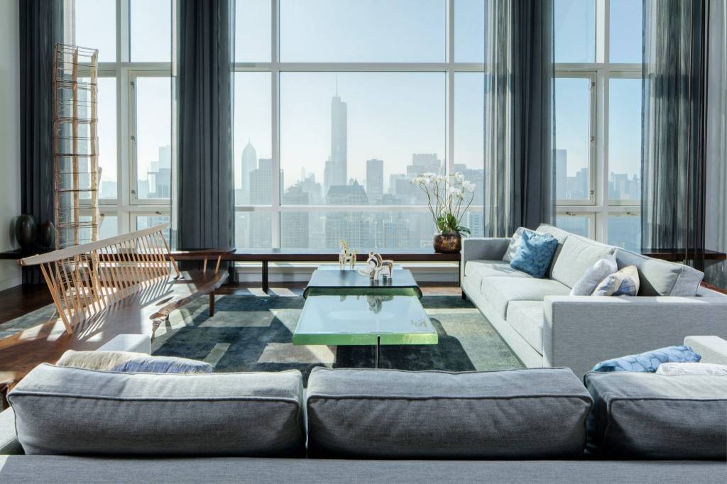 10-interiores-com-decoracao-calma-para-aliviar-o-estresse-casa.com-10 Em frente às janelas do chão ao teto, um grupo de sofás em cores claras é combinado com um tapete combinando em tons calmos de cinza e branco, enquanto uma mesa de centro de vidro seagreen capta a luz das janelas.