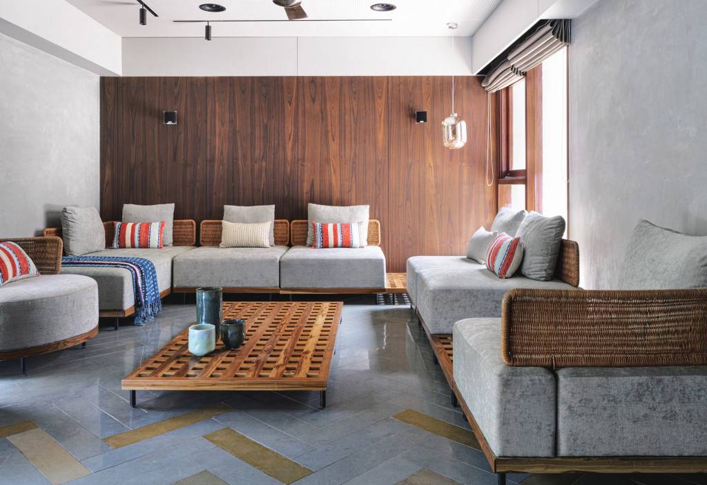 10-interiores-com-decoracao-calma-para-aliviar-o-estresse-casa.com-4 Sala de estar minimalista com sofá cinza, com almofadas coloridas e madeira em uma das paredes