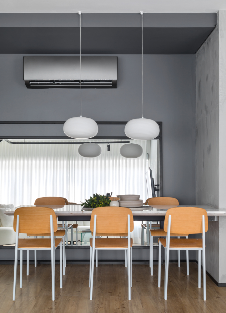 estudio-de-73-m²-com-planta-integrada-e-design-moderno-casa.com-archdaily-studio-gabirel-bordin-fabio-junior-severo-4 Mesa de jantar com cadeiras de estrutura branca e assento e encosto de madeira. com duas luminárias pendentes e espelho ao fundo