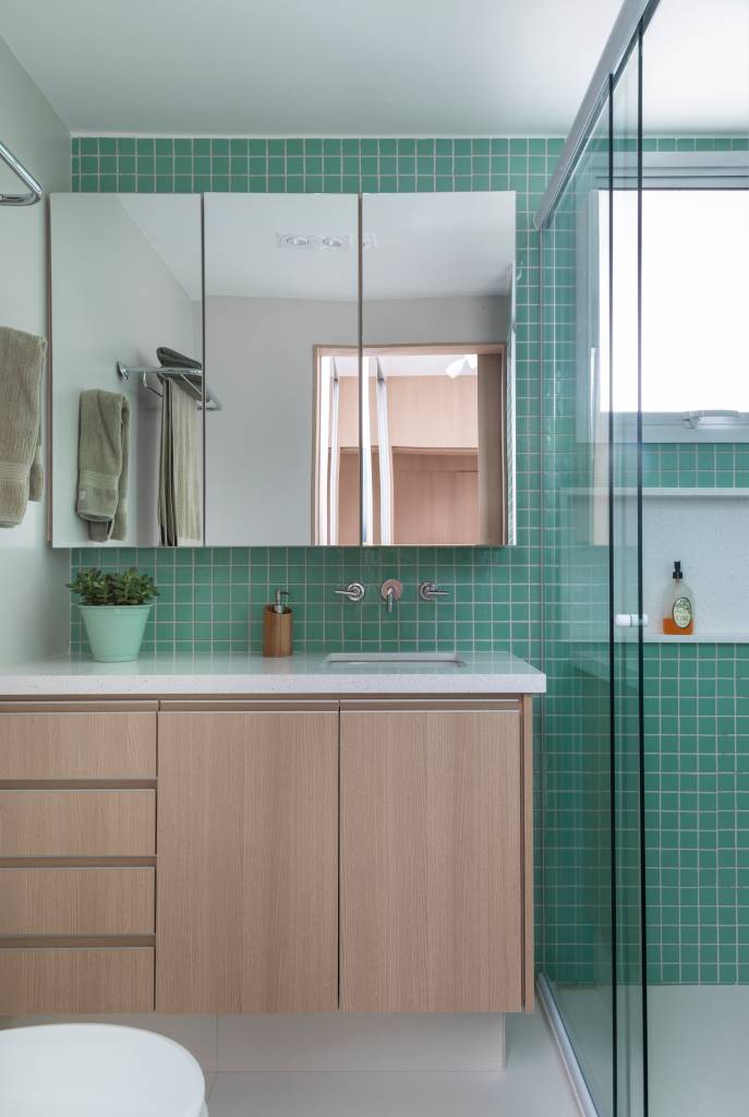 modernidade-e-leveza-no-decor-casa.com _MG_2111 Banheiro com móvel de madeira clara e bancada em pedra branca. Na parede, ladrilhos verde claro e um móvel com espelho