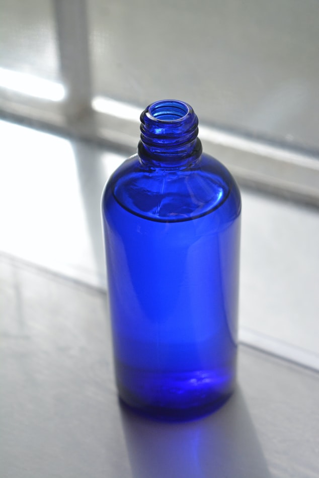 minimize-os-riscos-a-saude-durante-a-limpeza-com-estas-dicas-casa.com-6-unsplash-christina-deravedisian emabalagem azul com liquido dentro sobre bancada de pedra