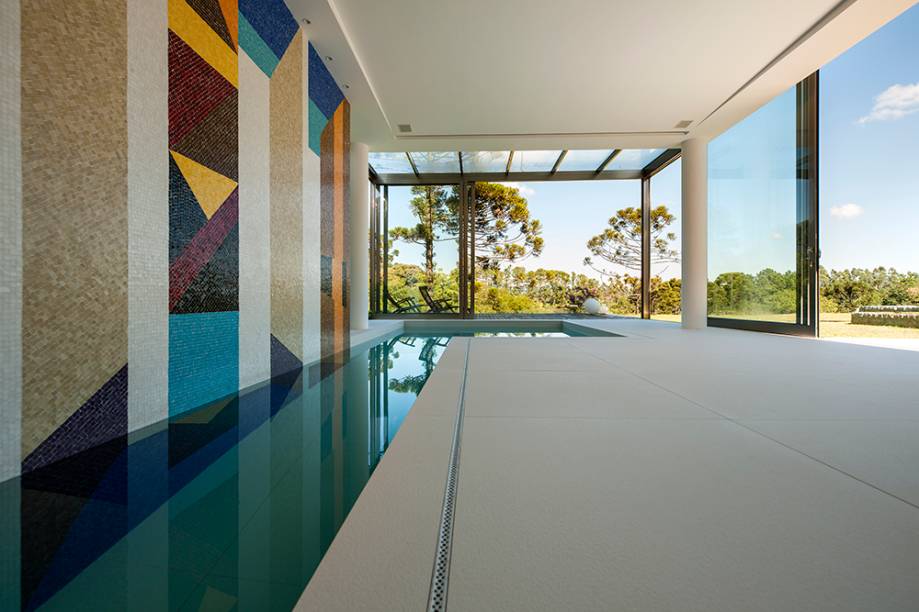 Com 5,70m de largura x 4,60m de altura e executado com pastilhas de vidro, o mural da piscina coberta foi uma encomenda dos clientes e leva a assinatura do próprio arquiteto Noel Marinho