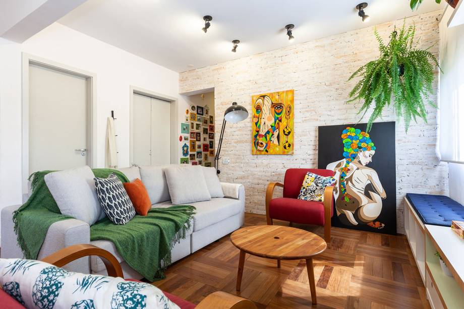 A explosão de cores presentes nos elementos escolhidos pelas arquitetas Bianca Atalla e Fernanda Mendonça, do Oliva Arquitetura, deixaram a sala, com base neutra e amadeirado claro, ainda mais estilosa e personalizada. Poltronas vermelhas, quadros, manta e o verde natural das plantas proporcionaram alegria e leveza.