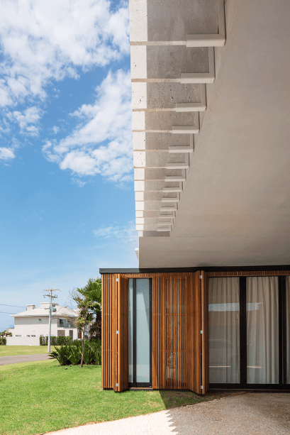 A fim de controlar o calor em excesso, a equipe do escritório Arquitetura Nacional colocou brises fixos de mármore itaúnas diante desta casa em Xangri-Lá, litoral do Rio Grande do Sul. Depois de flameadas (submetidas às chamas de um maçarico, adquirem aspecto rugoso), as lâminas de 3 cm de espessura foram presas junto às janelas dos quartos com o auxílio de perfis de aço com formato em L, pintados em tom claro.