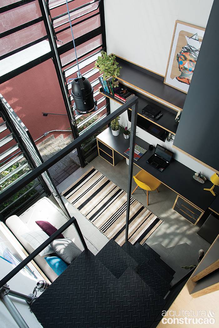 Os 22,60 m&sup2; concentram sala, copa, banheiro, &aacute;rea de servi&ccedil;o (no t&eacute;rreo) e quarto (no mezanino), de onde foi tirada esta foto. O p&eacute;-direito alto (5 m) e a farta luz natural evitam a sensa&ccedil;&atilde;o
de confinamento.