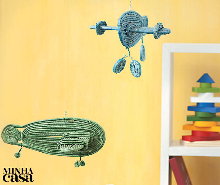 Que tal decorar o quarto das crianças com estes móbiles fofos? Faça três círculos de canudinhos de jornal de tamanhos diferentes: um para o corpo do avião, um para as asas e outro para a cauda. Aperte-os para moldá-los no formato oval. Fixe as peças com cola. Arremate o avião contornando-o com duas voltas de canudinhos. Confeccione as rodas com tiras fininhas.