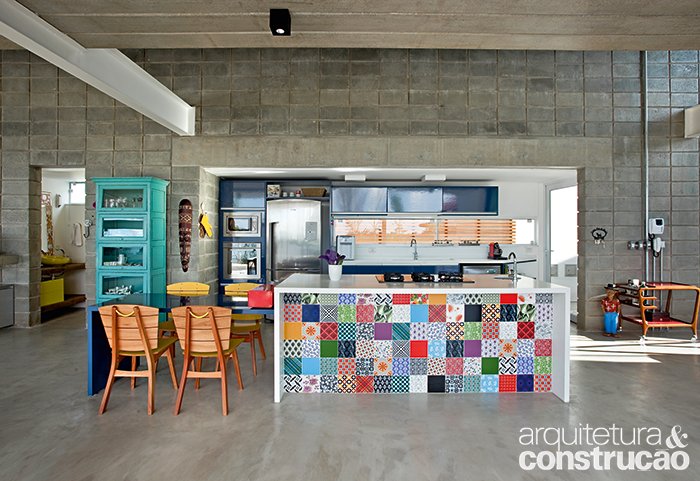 Numa base predominantemente cinza,com blocos de concreto aparentee piso de cimento queimado (Bautech,vendido pronto pela Ctori), a bancadada cozinha sobressai. Feita dealvenaria, ela tem azulejos coloridos(Antigua), tampo e laterais de QuartzoStone (da PKO, comprada naMarmoraria Carmona). Parafusadanela está a mesa (da Elgin, mesmofornecedor dos armários ao fundo). Numa base predominantemente cinza,com blocos de concreto aparentee piso de cimento queimado (Bautech,vendido pronto pela Ctori), a bancadada cozinha sobressai. Feita dealvenaria, ela tem azulejos coloridos(Antigua), tampo e laterais de QuartzoStone (da PKO, comprada naMarmoraria Carmona). Parafusadanela está a mesa (da Elgin, mesmofornecedor dos armários ao fundo).