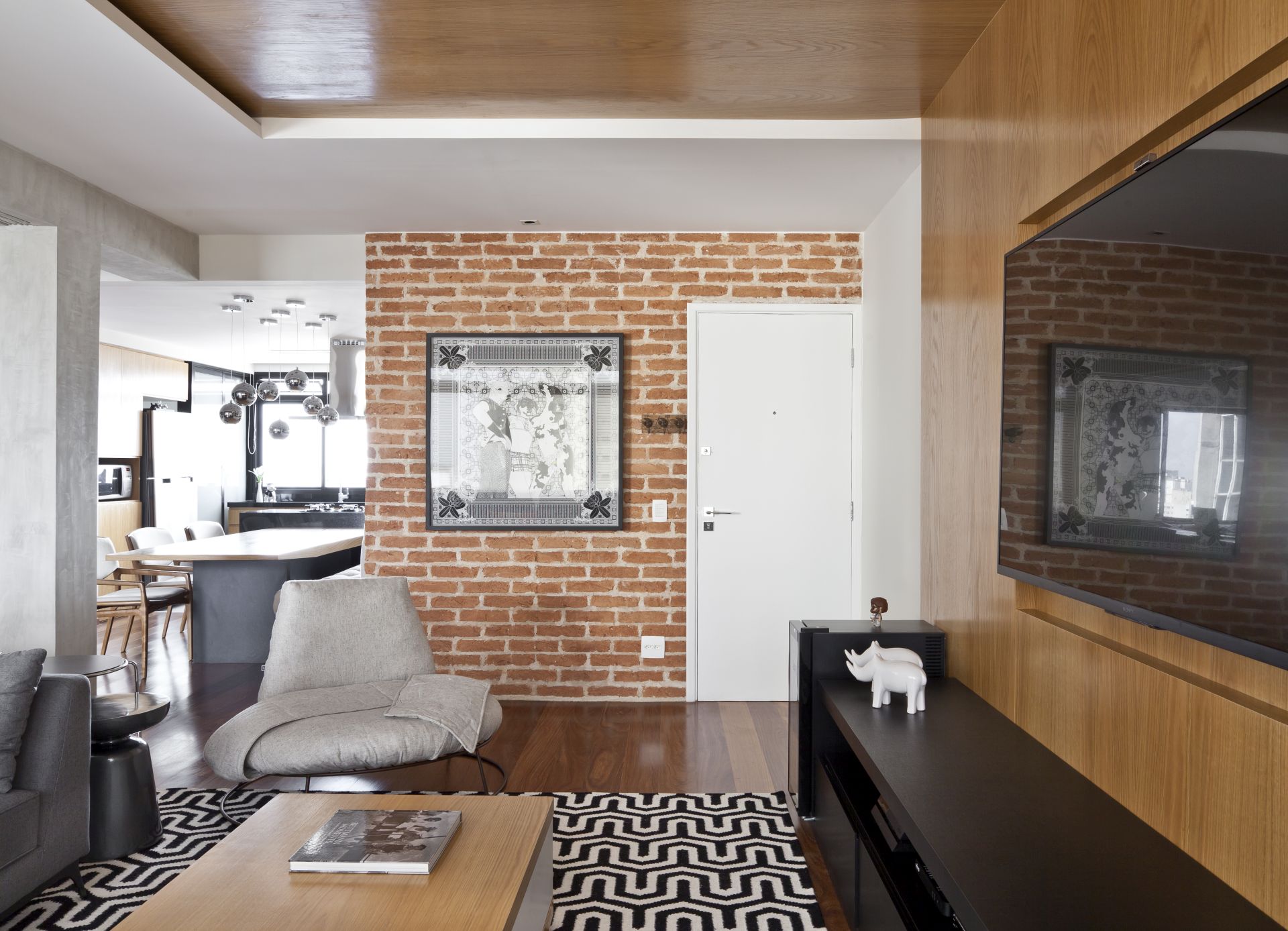 A divis&oacute;ria do hall de entrada exibe os blocos cer&acirc;micos (Companhia das Telhas), que oferecem uma dose de aconchego ao apartamento com voca&ccedil;&atilde;o de loft.
