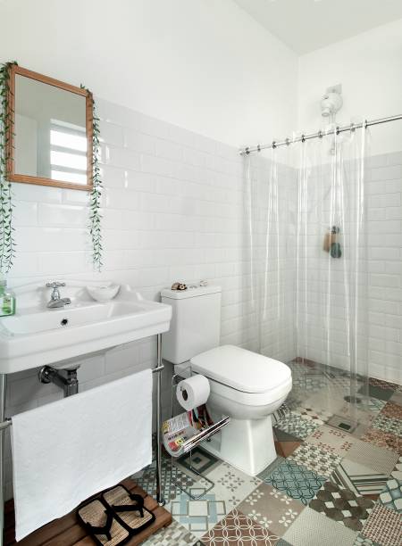 <span>O ar antiguinho deste projeto foi conquistado graças ao casamento do porcelanato com aparência de ladrilho hidráulico no piso (similar: Oxford Deco, da Biancogres, de 60 x 60 cm. C&C) com os subway tiles – os famosos azulejos das estações de metrô europeias – (modelo Metro White, da Eliane, de 20 x 10 cm. C&C), que cobrem todas as paredes até a altura de 1,80 m. A cortina de plástico transparente protege a área seca dos respingos e garante que a composição fique à mostra.</span>