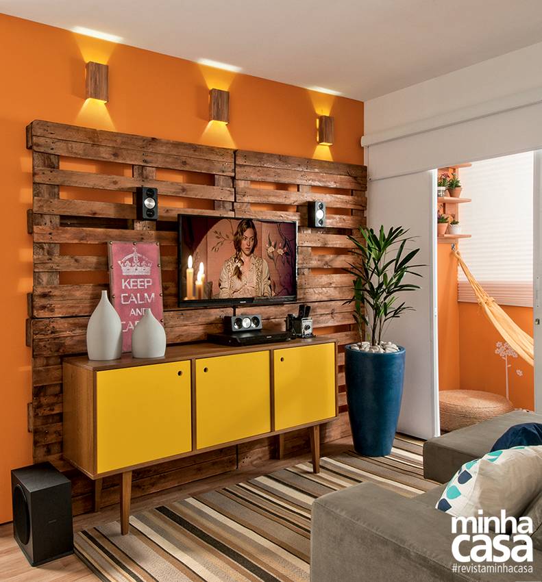 Reaproveitar &eacute; chique e beneficia o planeta! O painel da TV comp&otilde;e-se de paletes de eucalipto tratados com verniz mar&iacute;timo (ref. C192V, da Suvinil). Projeto do arquiteto Glaucio Gon&ccedil;alves, do escrit&oacute;rio paulistano EB-A - Espa&ccedil;o Brasileiro de Arquitetura.