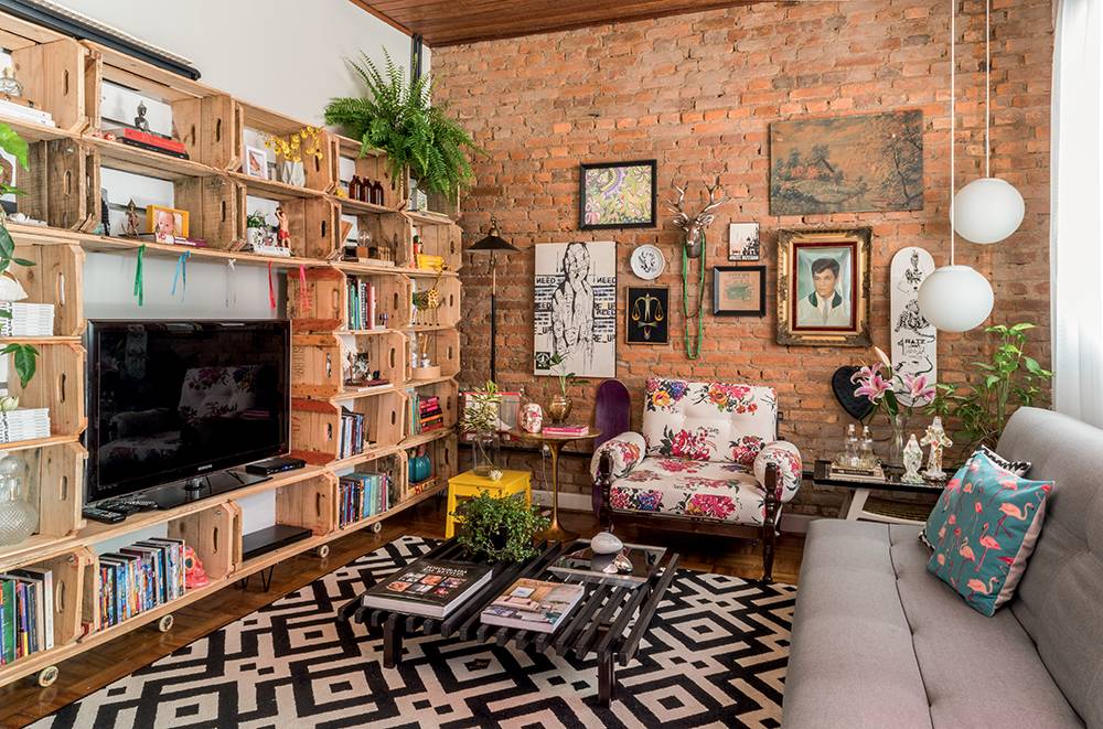 <p style="text-align:justify;">Estrela do estar, o m&oacute;vel, feito pela designer de interiores Erika Kapuk com duas d&uacute;zias de caixotes usados - comprados por R$ 10 cada em hortifr&uacute;tis da regi&atilde;o - mede 3,30 x 2 m e abriga a TV, livros e outros objetos. "Gosto da apar&ecirc;ncia r&uacute;stica da madeira: apenas lixei bem para que n&atilde;o soltassem farpas e pintei os fundos de branco, deixando o visual mais leve." Em seu canal de v&iacute;deos no YouTube, ela ensina a reproduzir a ideia: <a href="https://youtu.be/RNroQmkntAI" target="_blank" rel="noopener">goo.gl/9PKTWY</a></p>