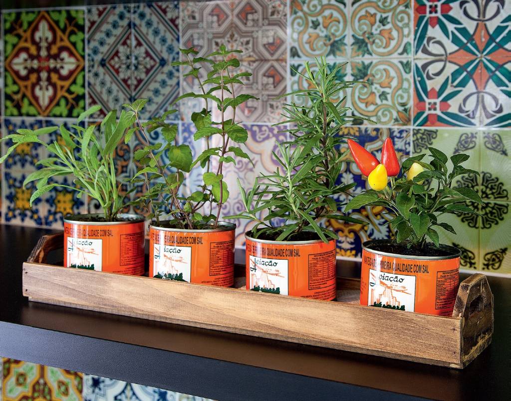 horta-mosaico-de-adesivos-vintage-transforma-cozinha-em-curitiba 3 dicas para ter uma horta em espaços pequenos. Na foto, hortaliças plantadas em latinhas de manteiga.
