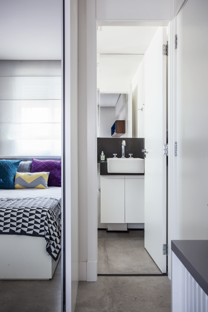 Da cama o morador enxerga o banheiro da suíte. Na lateral do móvel existem uma mesinha de cabeceira e uma sapateira ripada (abaixo, na foto). Da cama o morador enxerga o banheiro da suíte. Na lateral do móvel existem uma mesinha de cabeceira e uma sapateira ripada (abaixo, na foto).