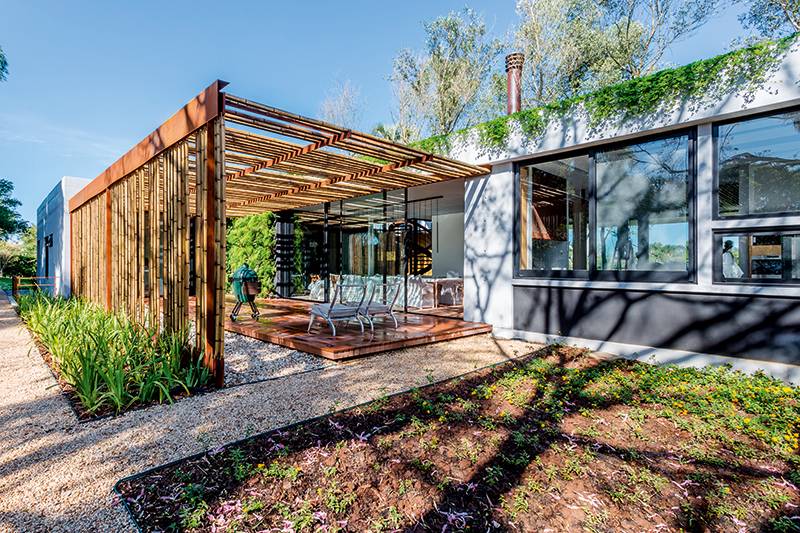Acabamentos especiais: O pergolado de 12 m de comprimento foi feito com bambu, presente tamb&eacute;m nas persianas e em detalhes do forro. No piso da casa, usou-se cumaru certificado. V&acirc;nia B&uacute;rigo assina o design de interiores.