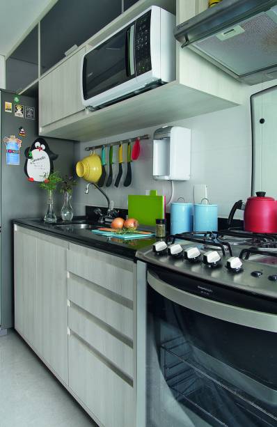 <span>Apenas um lado do ambiente recebeu marcenaria, tendo em vista a melhor área de circulação. As portas dos módulos superiores, de vidro preto, dão charme aos móveis de madeira clarinha. Projeto do arquiteto André Bove.</span> <span>Apenas um lado do ambiente recebeu marcenaria, tendo em vista a melhor área de circulação. As portas dos módulos superiores, de vidro preto, dão charme aos móveis de madeira clarinha. Projeto do arquiteto André Bove.</span>