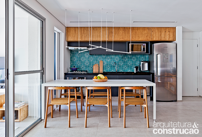 A cozinha limita-se a uma faixa aberta para a sala. Da&iacute; a import&acirc;ncia de acabamentos com jeito de estar, como o azulejo estampado, desenho dos pr&oacute;prios arquitetos. Bancada de granito s&atilde;o gabriel (Pedracor) e arm&aacute;rios da Kitchens.