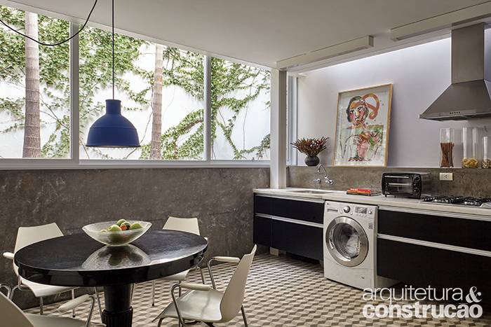 Note que a cozinha com copa inclui uma área de lavanderia, onde uma lavadora intercala-se entre os armários de laminado preto (Formaplas). Apesar de os ambientes ficarem semienterrados, não são escuros, já que o janelão de alumínio (Kiko Esquadrias) vai de uma lateral à outra, fixadoacima do barrado revestido de cimento queimado. Feita de concreto, essa base denota o reforço nos alicerces. Note que a cozinha com copa inclui uma área de lavanderia, onde uma lavadora intercala-se entre os armários de laminado preto (Formaplas). Apesar de os ambientes ficarem semienterrados, não são escuros, já que o janelão de alumínio (Kiko Esquadrias) vai de uma lateral à outra, fixadoacima do barrado revestido de cimento queimado. Feita de concreto, essa base denota o reforço nos alicerces.