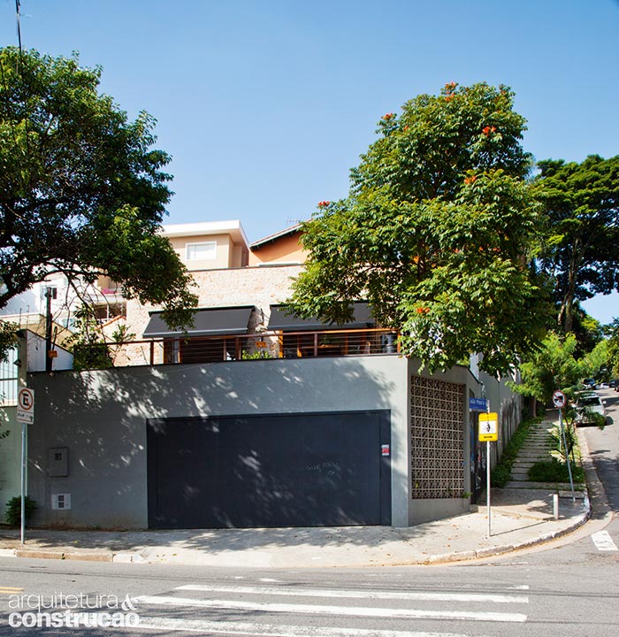 Ao retirar o telhado e adotar o formato de caixa por meio de uma laje plana com platibanda, a casa ganhou visual moderno. Nota-se, deste &acirc;ngulo, o aclive do terreno.