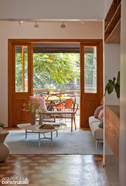 Presentes não só na sala de estar, as portas-balcão favorecem a integração, a circulação de ar e a entrada de luz natural. Sofá, mesa de centro, poltrona de madeira do estudiobola, tapete da Square Foot. Presentes não só na sala de estar, as portas-balcão favorecem a integração, a circulação de ar e a entrada de luz natural. Sofá, mesa de centro, poltrona de madeira do estudiobola, tapete da Square Foot.