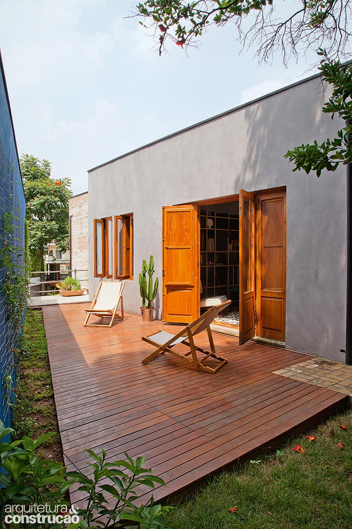 Este deck ocupa a &aacute;rea resultante de uma manobra complicada mas necess&aacute;ria: o jardim, que subia acompanhando a inclina&ccedil;&atilde;o da rua lateral, precisou ser escavado at&eacute; chegar na altura do quarto do casal. Os arquitetos aproveitaram para acomodar uma cisterna embaixo do tablado. Cadeiras Fernando Jaeger.