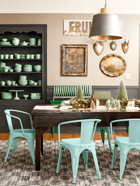 Árvores pequenas de Natal preenchem o centro desta mesa junto com outros enfeites festivos.