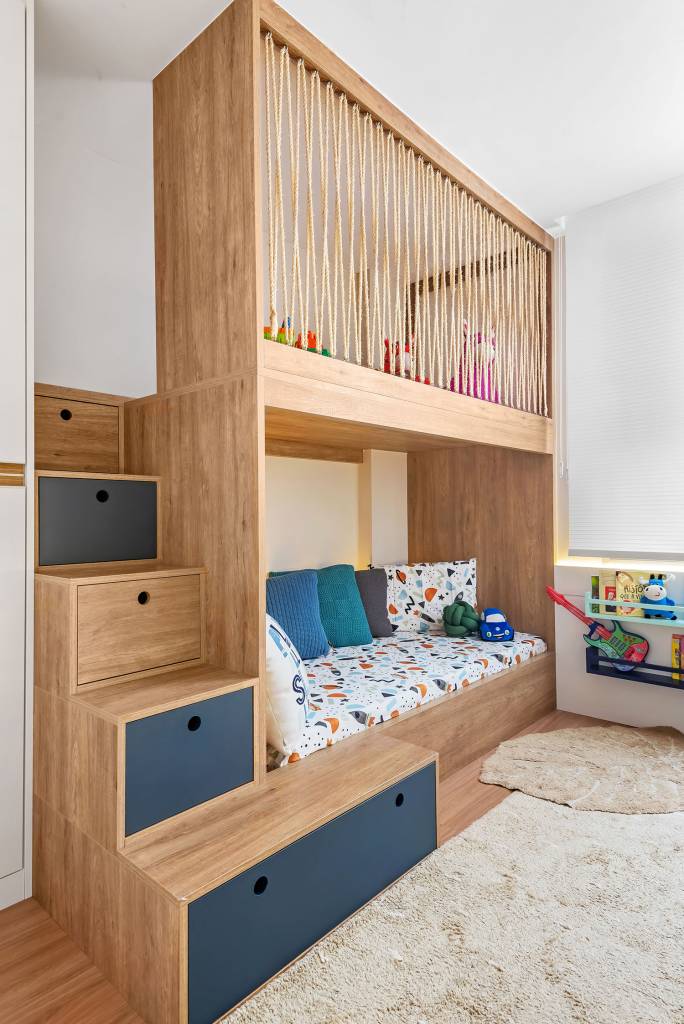 Quarto infantil com cama de madeira e área de brincadeira na parte superio da beliche