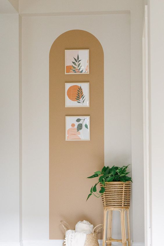 arco-neutro Arco neutro em uma parede branca com 3 quadros e uma planta posicionada no chão