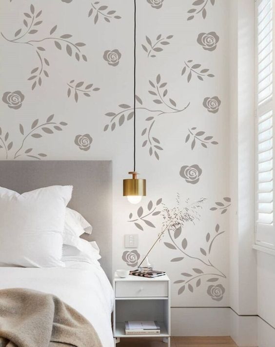 parede branca recebe desenhos em cinza de rosas