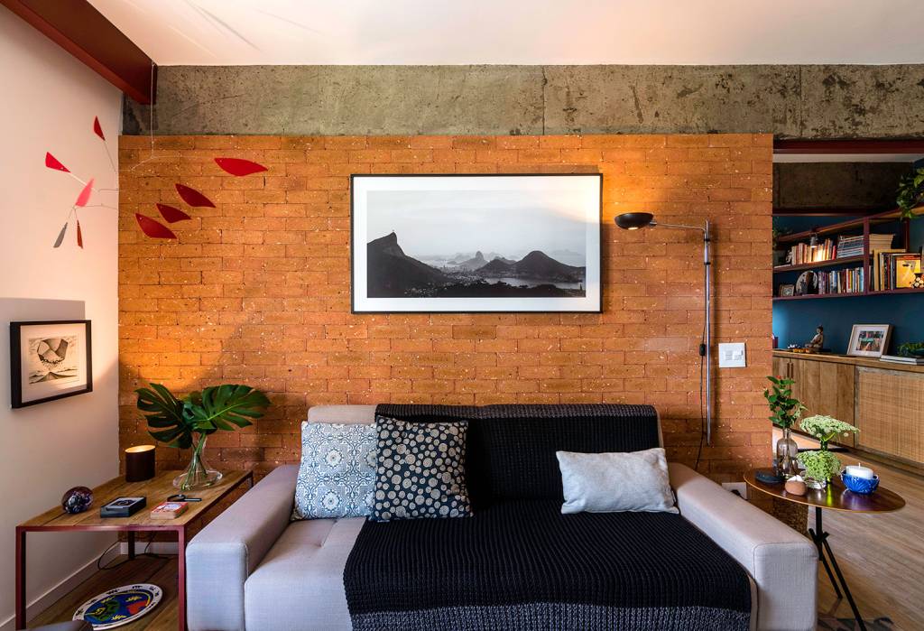 reforma-garante-personalidade-e-conforto-para-um-apartamento-de-70-m²-casa.com-hoearquitetura-eli-k-hayasaka-12-sofá-com-parede-de-tijolinhos Parede de tijolinhos atrás do sofá branco com um grande paisagem em preto e branco emoldurada