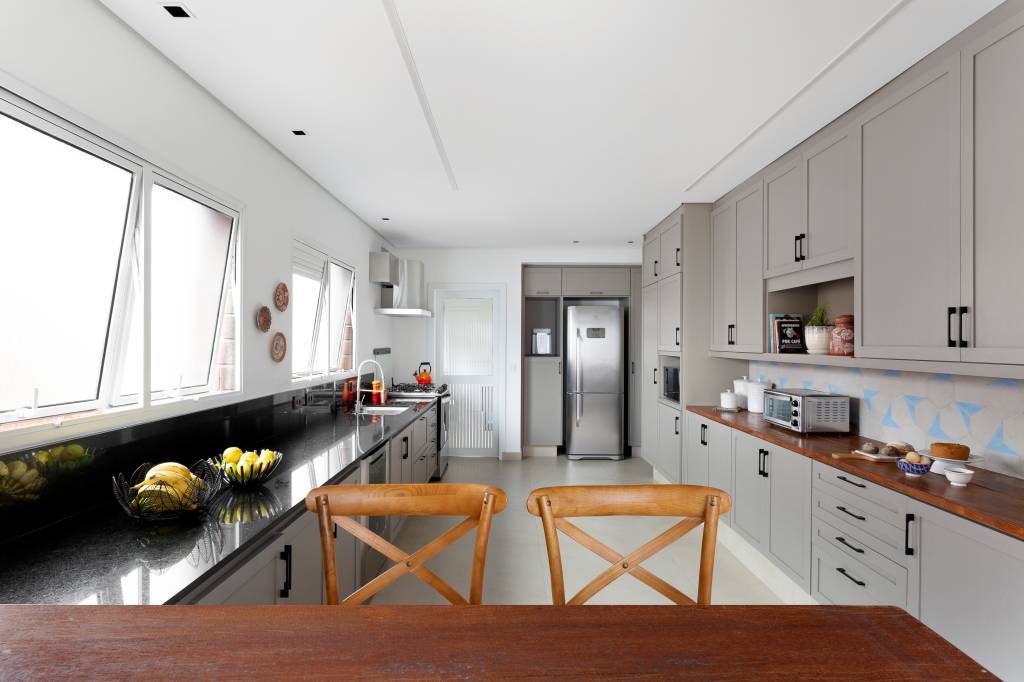 1-estilo-contemporaneo-e-easy-chic-definem-ape-jovem-em-sao-paulo Cozinha com armários cinzas e cadeira de madeira
