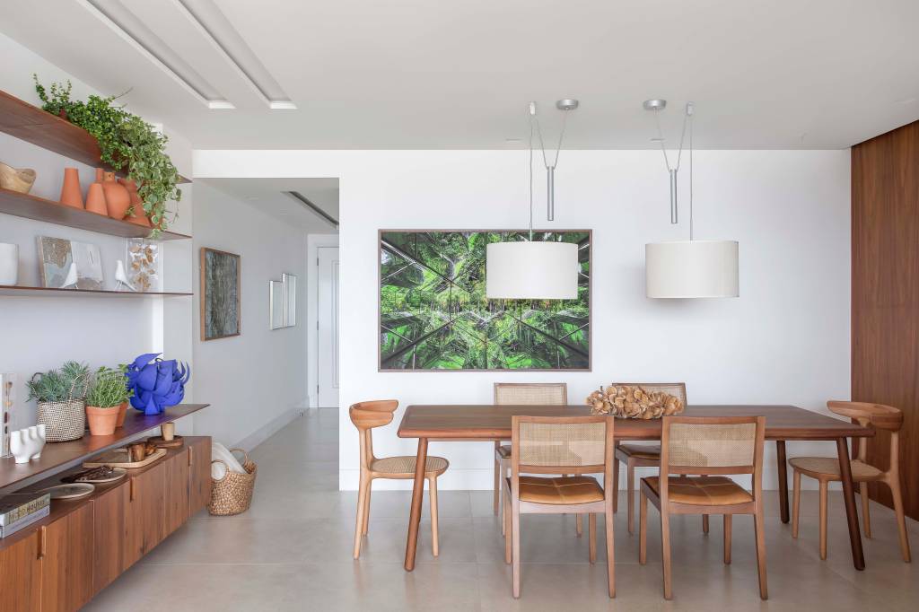 9-refúgio-à-beira-mar-confira-este-apê-com-vista-incrível-e-toques-praianos Sala de jantar integrada ao estar com cadeiras de madeira e tons neutros