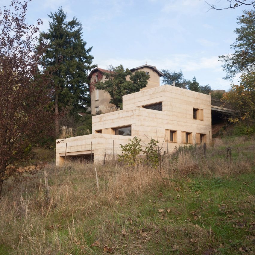 quem-disse-concreto-precisa-ser-cinza-jérôme-ricolleau-casa-fachada-cor-de-terra Casa semienterrada em paisagem bucólica de floresta tem fachada em tom de areia.