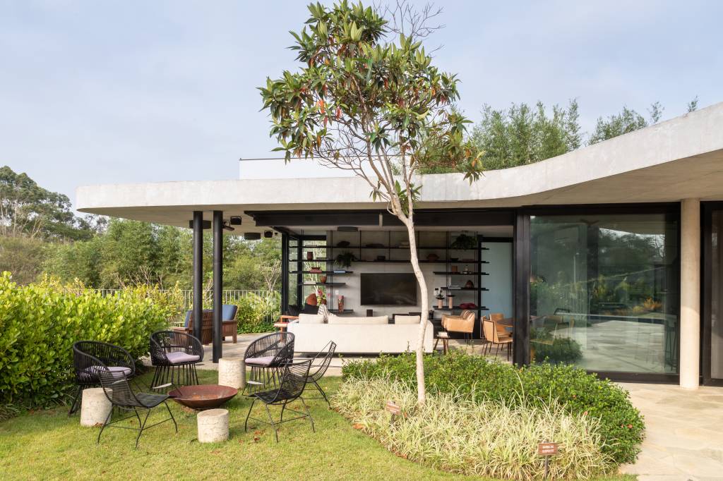 Lado externo de casa modernista com árvore na frente