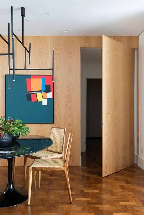 8-maneiras-simples-deixar-casa-confortavel-aconchegante-landhi-vivi-cirello-madeira-mesa-cadeira-quadro Sala de jantar com mesa redonda, cadeiras e quadro na parede