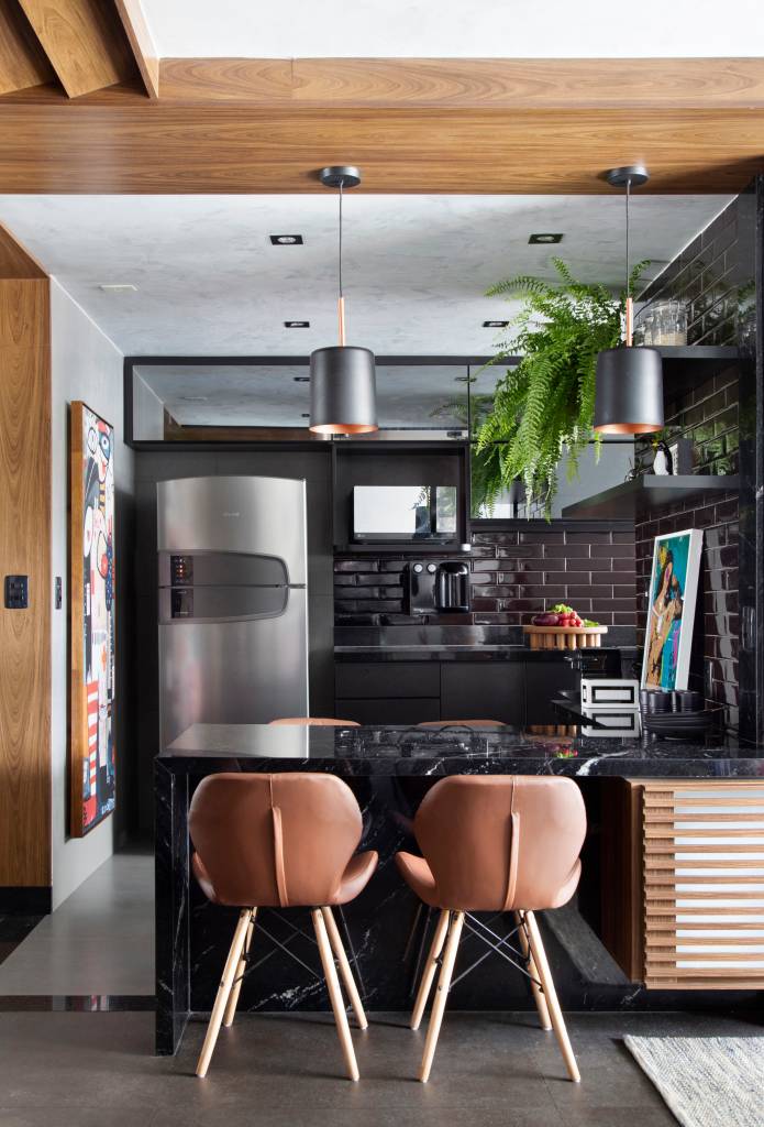 Apartamento masculino no bairro Santa Rosa em Niterói assinado pelo STUDIO LIVIA AMENDOLA _ foto 2-cozinha-preto Cozinha integrada com estar; mesa preta; cadeiras em couro marrom
