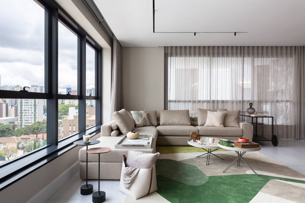 Moderno-e-orgânico-a-trend-para-se-reconectar-com-a-natureza-Casa.com.br-Eduardo-Macarios-decoração-dicas-inspiração-sala-de-estar Sala com móveis e paredes em tons complementares de branco, bege e marrom. O destaque fica para o tapete verde.