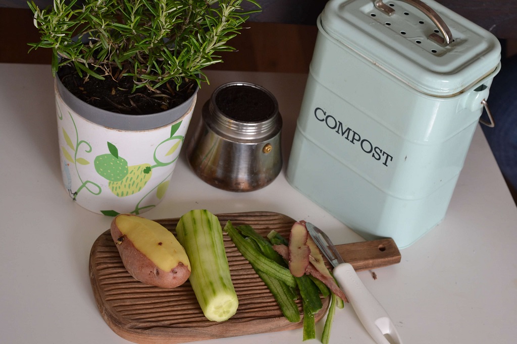 como-separar-destinar-lixo-ciclovivo-Lenka Dzurendova-Unsplash Mesa de cozinha com legumes descascados em tábua. Recipiente de compostagem ao lado