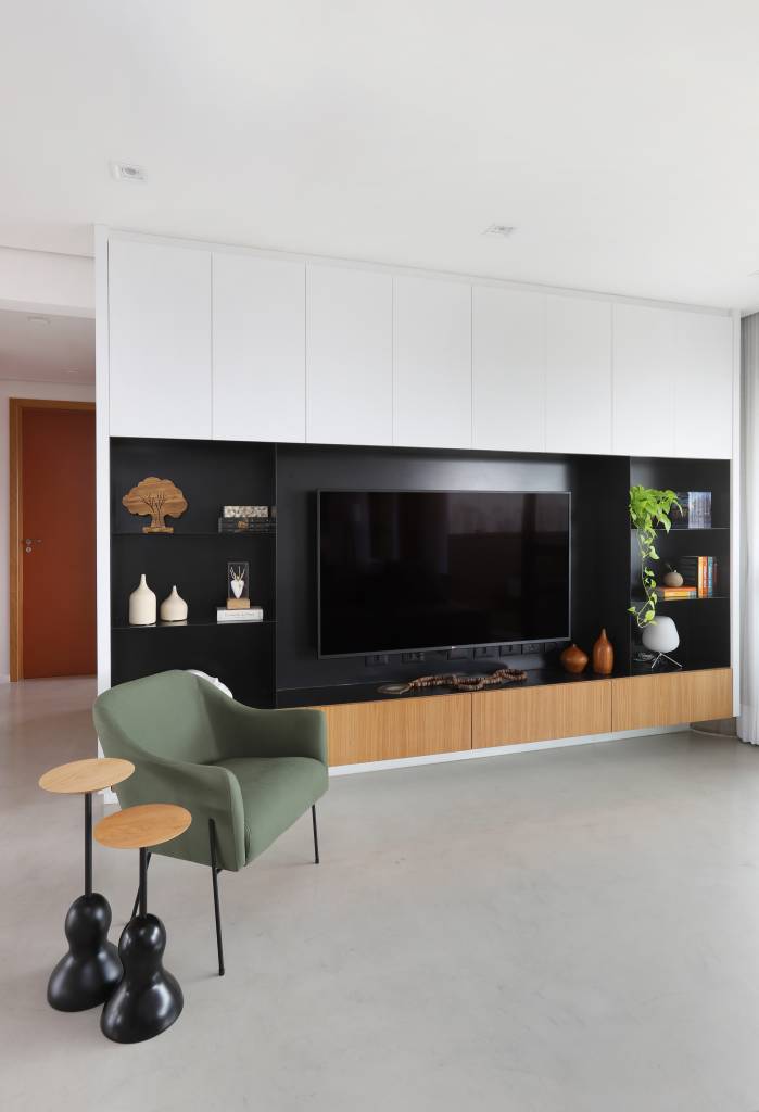 1-estilo-industrial-arte-e-integracao-marcam-este-apartamento-em-sao-paulo Painel preto para TV em sala de estar, poltrona verde e mesinha de madeira