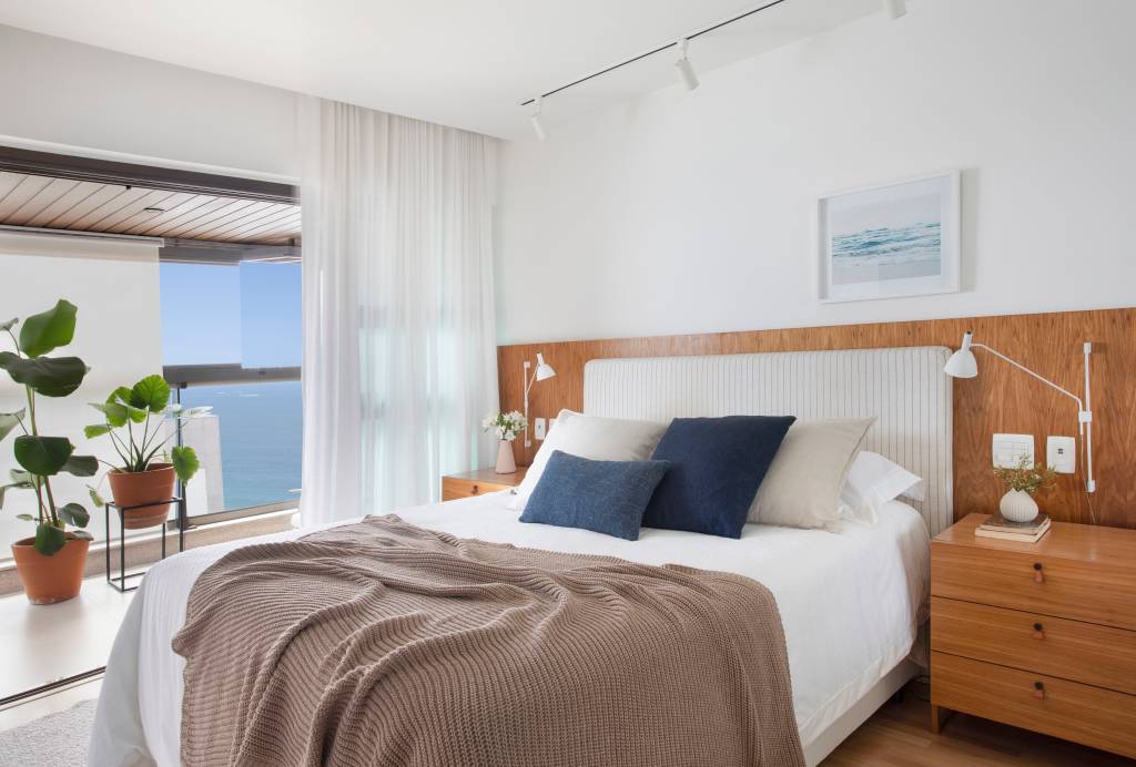 17-reforma-deixa-ape-de-150-m-2-mais-iluminado-e-com-ambientes-leves Quarto de casal com décor branco e com madeira com vista para Rio de Janeiro